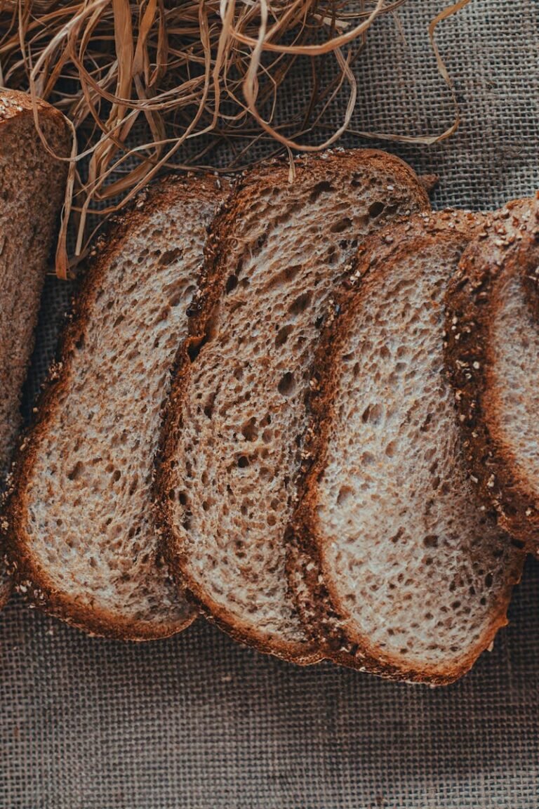Sliced whole wheat bread arranged on burlap, showcasing crunchy texture and rustic appeal.